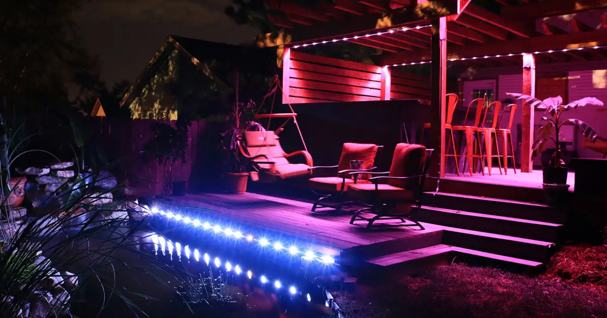 Outdoor patio with color changing LED lighting and illuminated deck creating vibrant nighttime ambiance