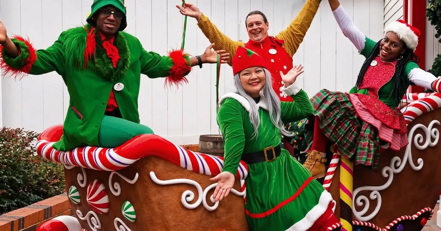 Performers in festive costumes posing on a colorful holiday parade float