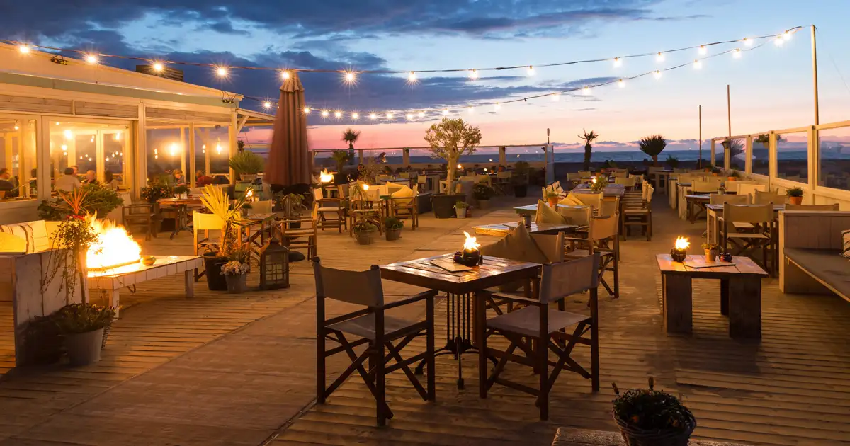 Outdoor pergola with string lights and cozy seating area illuminated for nighttime relaxation