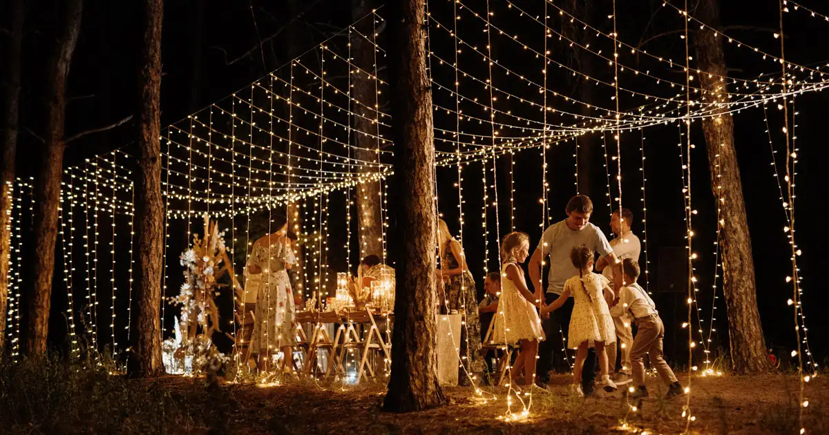 Outdoor tent reception with string lights creating soft and elegant wedding lighting ambiance
