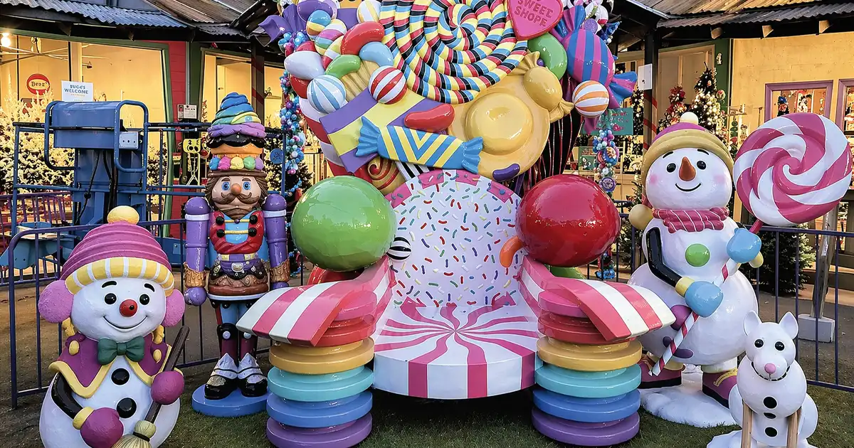 Candy-themed holiday display with oversized sweets, snowmen, and vibrant decorative elements