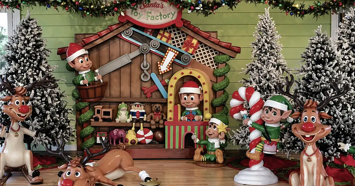 Santa workshop themed display with elves, toys, and Christmas decorations