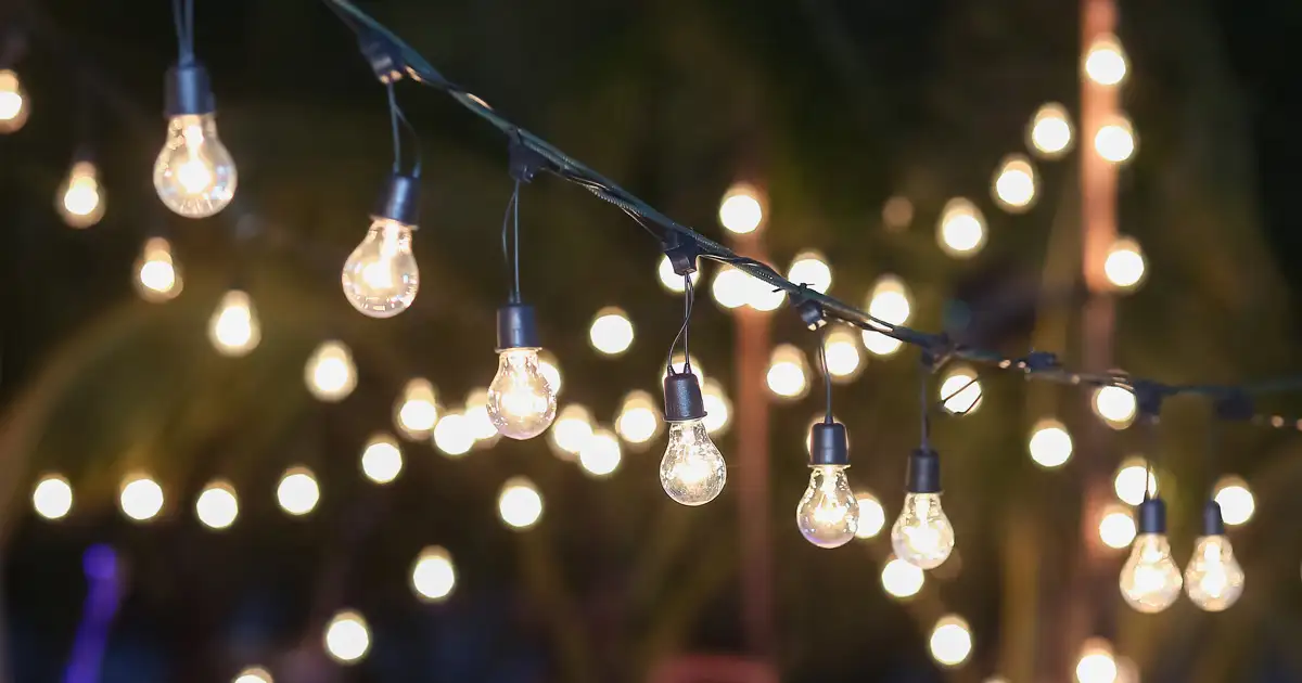 String lights installed above outdoor seating area for decorative and functional patio lighting