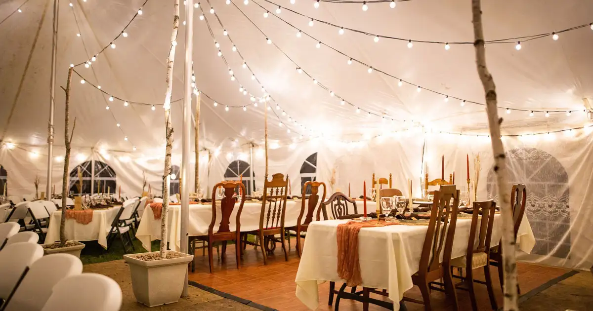 Elegant event table setup with candles and string lights creating romantic dining ambiance