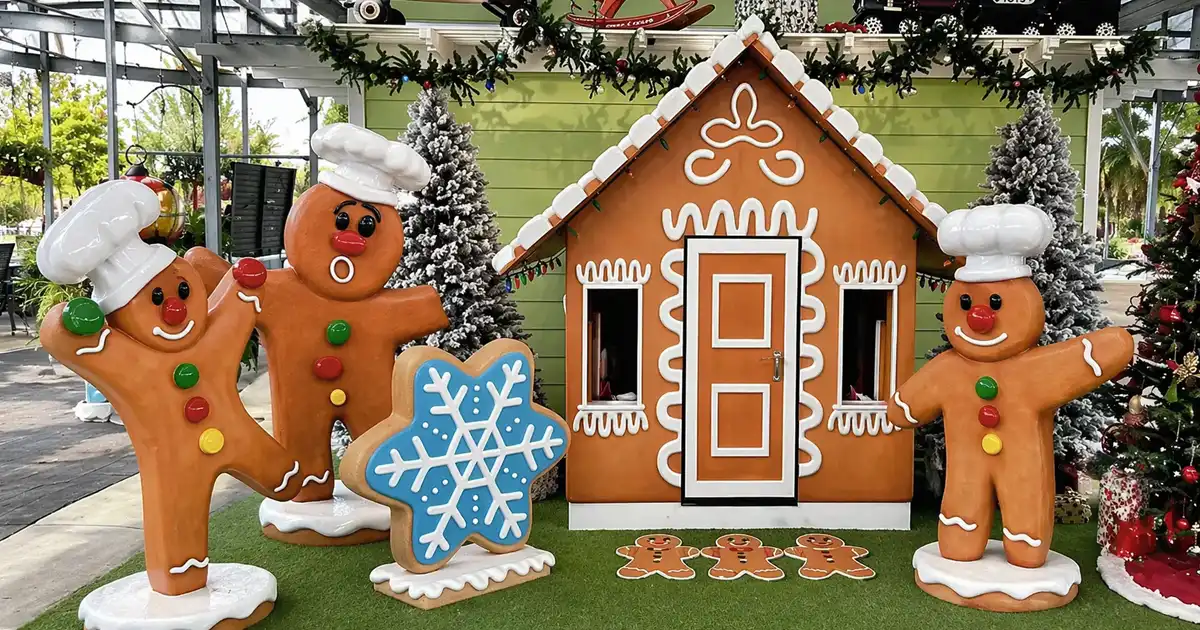 Gingerbread house display with oversized cookies and festive holiday characters