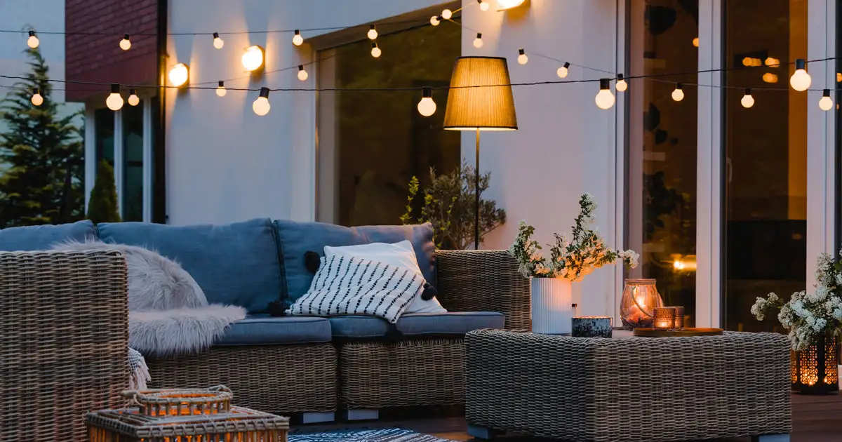 Beachside gathering with decorative string lights creating a relaxed outdoor event lighting setup
