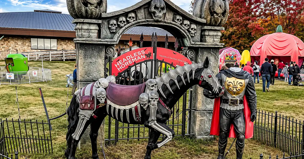 Halloween-themed display featuring skeleton horse and spooky entrance arch at outdoor event