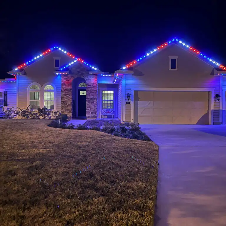 Residential home with permanent roofline lighting in red and blue LED colors for decorative exterior lighting